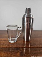 Shaker and glass side by side on tabletop