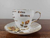 Teacup on saucer front view showing pattern and text