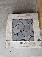 Closed box showing slate mosaic sheets through cut-out