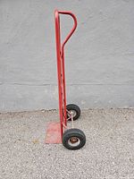 Side view showing D-handle, frame and wheels