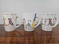 Front view of three mugs showing designs
