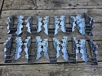 Multiple rows of joist hangers laid out on wooden surface