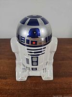 Front view of R2-D2 ceramic coin bank showing coin slot on dome and body detailing