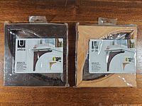 Both sealed packages of Umbra wood shelf brackets side by side