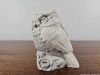 Front view of ivory owl figurine showing detailed feathers and branch base