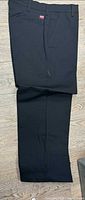 Full view of black Red Kap work pants laid flat
