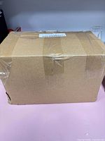 Sealed brown shipping box containing the caster wheels