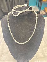 Necklace draped on bust with bracelets placed on top, showing overall design