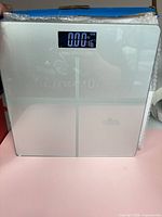 Front view of glass bathroom scale showing LCD and platform
