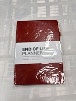 Front view of sealed red hardcover planner with label