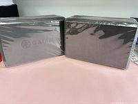 Two sealed grey Gaiam yoga blocks side by side