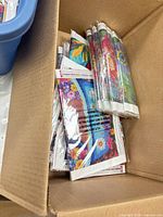 Open cardboard box filled with individually wrapped diamond painting canvases