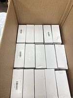 open carton showing sixteen identical white boxes of diamond art glue