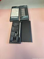 Two closed retail boxes showing product name 2025A and one opened case displaying handle and bits