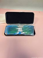 Blue/green mirrored clip-on lens sealed in plastic inside black hard case