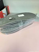 Sealed pair of slippers showing soles and packaging