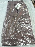 Folded brown women’s cargo pants sealed in clear plastic bag