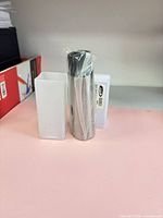 Sleeve in plastic wrap alongside open plastic storage tube