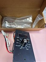 Controller faceplate, dial and wiring harness beside sealed harness in box