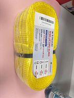 Front view of sealed yellow web sling with label showing specifications