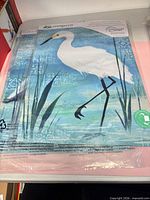 Front view of packaged garden flag showing blue heron design and Evergreen branding