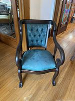 Front view of dark wood Empire style armchair with blue upholstered seat and tufted back