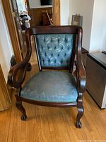 Front view of American Empire style armchair showing tufted back, upholstery, carved frame