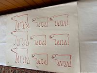 Full view of print showing nine red-outlined polar bears on off-white paper