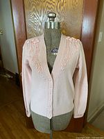 Front view of Laurin Cole pink cardigan on dressmaker’s form