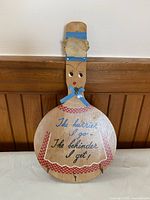 Front of wooden key holder showing painted design, ribbon bow and hooks