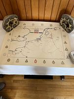 Full view of WWII Canadian Infantry Division map on table with stone weights