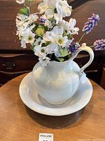 Pitcher in basin with flowers