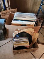Cardboard box and basket containing LP records and 7-inch singles