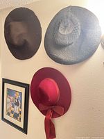 Wall view showing three hats and framed print