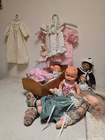 Group shot of all dolls, cradle and hanging clothing