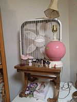 Overall view of table with fan, lamp, shoes, mini houses, figurines, grape cluster