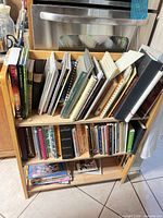 Books on two-tier wooden shelf, various craft subjects