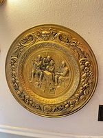 Full view of round brass charger hung on wall