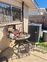 Overall lot showing patio table with decor, trellis, wine rack and vases