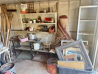 Overall view of garden tools, shelving, rug, frames
