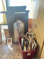 Overview with wardrobe cabinet, carved frame, mirror, red tote of frames