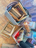 Overview of totes containing picture frames, framed art prints, rolled poster