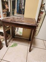 Full view of wooden table with casters