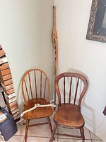 Overall view of both wooden chairs, plastic hanger on seat, cactus skeleton in corner
