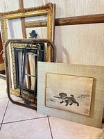 Group of three empty frames and mounted dog painting