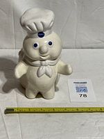 Front view of ceramic Pillsbury Doughboy utensil holder with measuring tape