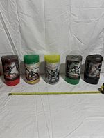 Five Bionicle canister sets side-by-side with measuring tape for scale