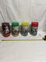 Group shot of the four Bionicle canisters with measuring tape for scale