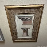 Full view of framed classical architectural column print with gold frame and marble-look mat