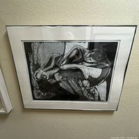 Framed monochrome figurative print with white mat and glass, showing mat warping and discoloration